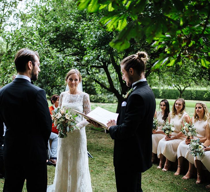 Outdoor Wedding Ceremony at Childerley Hall | Bride in Lace Sottero & Midgley Gown | Groom in Herrvon Eden Tuxedo | Tawny Photo