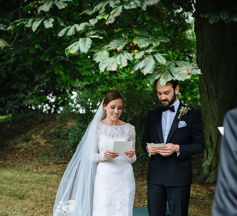 Outdoor Wedding Ceremony at Childerley Hall | Bride in Lace Sottero & Midgley Gown | Groom in Herrvon Eden Tuxedo | Tawny Photo