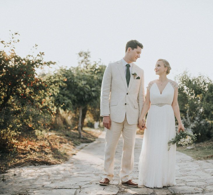 Bride in Catherine Deane Gown | Groom in Beige Austin Reed Suit | Outdoor Pastel Destination Wedding at Agreco in Greece | Best Moments Wedding Planner | Paulina Weddings Photography