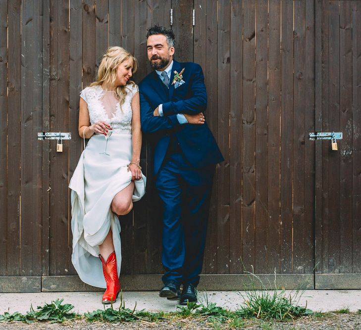 Bride in Red Cowboy Boots and Ivy & Aster Secret Garden Wedding Dress | Groom in Navy Reiss Suit | Rustic Wedding at Yoghurt Rooms in Sussex | Louise Griffin Photography