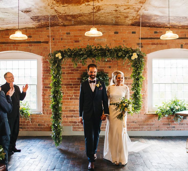 Bride in Charlie Brear Torum Dress & Adrianna Lace Jacket | Industrial Wedding Ceremony at The West Mill | Greenery Flower Arch | S6 Photography