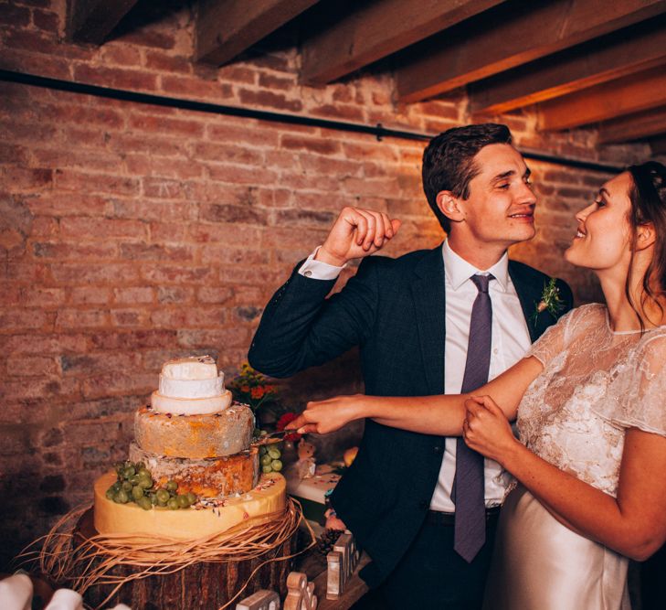 Bride & Groom Cutting the Cheese Tower Wedding Cake