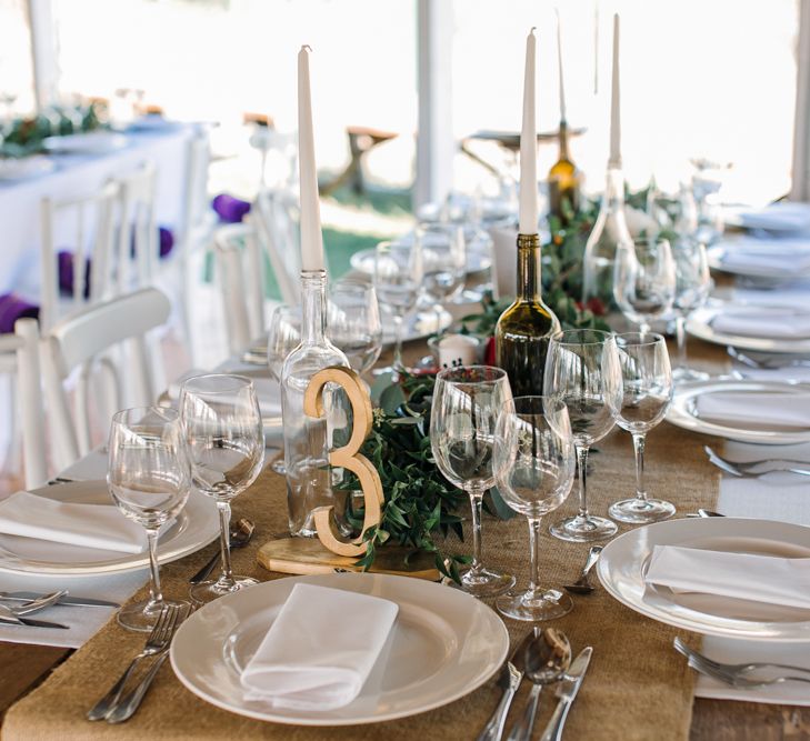 Wedding Reception Centrepieces with Greenery Table Runners & Tappered Candles in Bottles