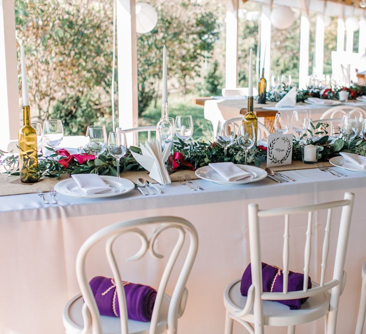 Wedding Reception Centrepieces with Greenery Table Runners & Tappered Candles in Bottles