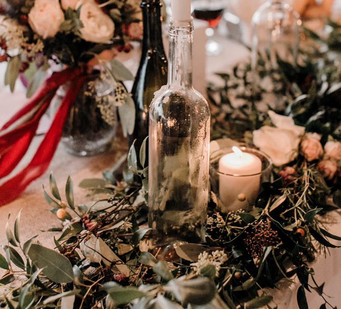 Wedding Reception Centrepieces with Greenery Table Runners & Tappered Candles in Bottles