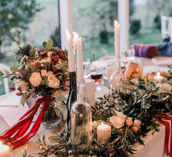 Wedding Reception Centrepieces with Greenery Table Runners & Tappered Candles in Bottles