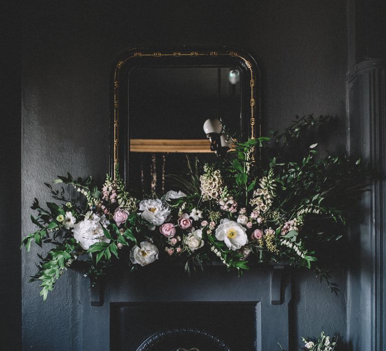 Shot of dark fireplace with pink wedding flowers on mantel - Moody Wedding Photographer