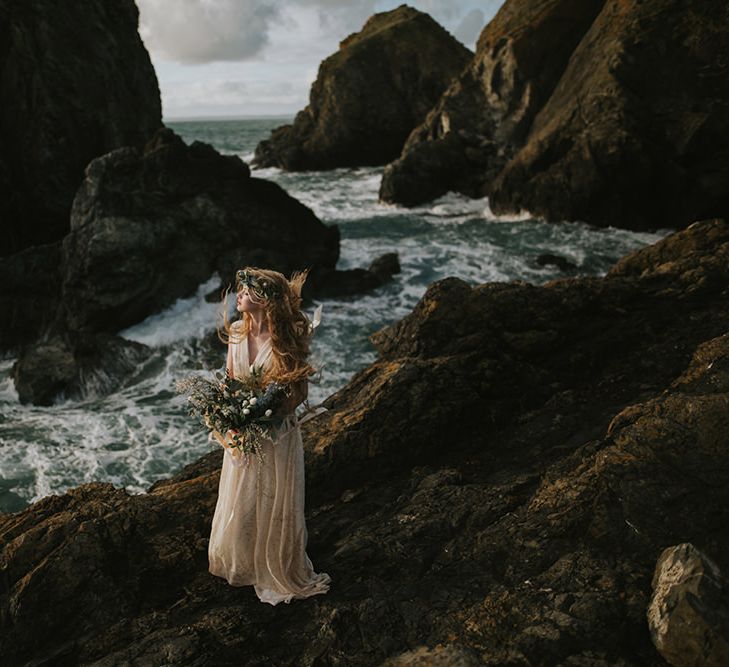 Bride standing amongst rocks at sunset - moody wedding photography