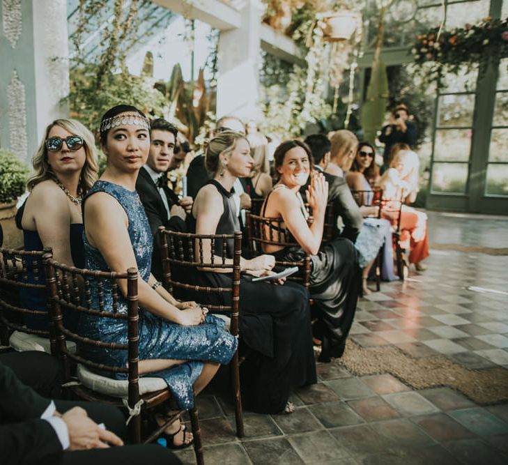 Seated wedding guests at ceremony turn to see couples entrance