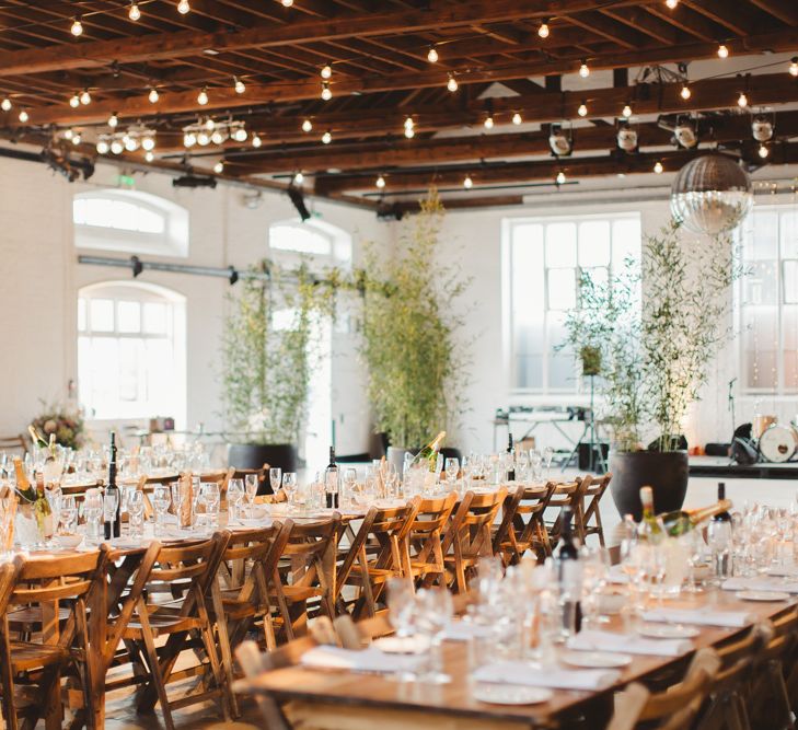 Warehouse Wedding With Wooden Chairs & Foliage Installation | Images by Frances Sales