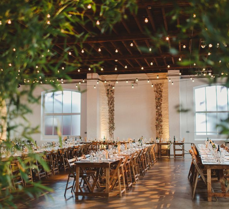 Warehouse Wedding With Wooden Chairs & Foliage Installation | Images by Frances Sales