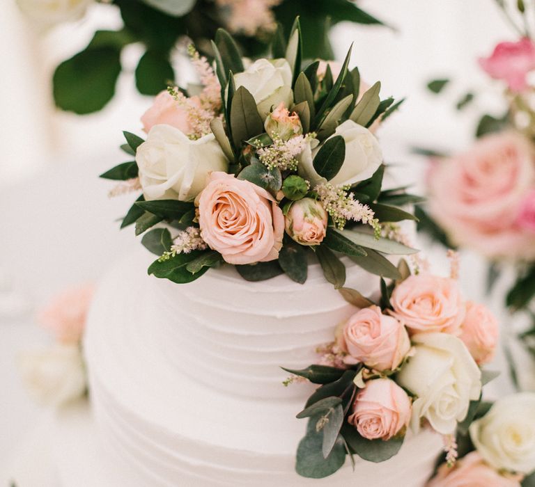 White Wedding Cake Covered In Flowers