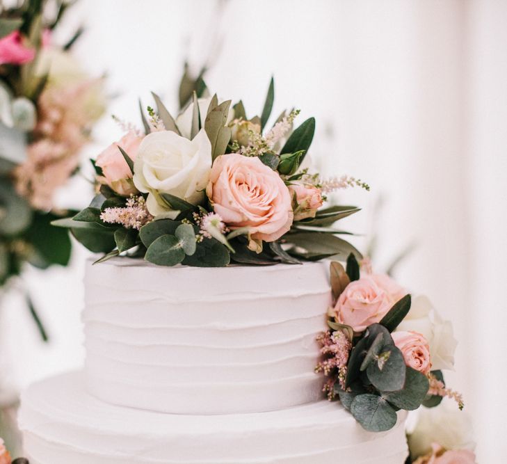 White Wedding Cake Covered In Flowers