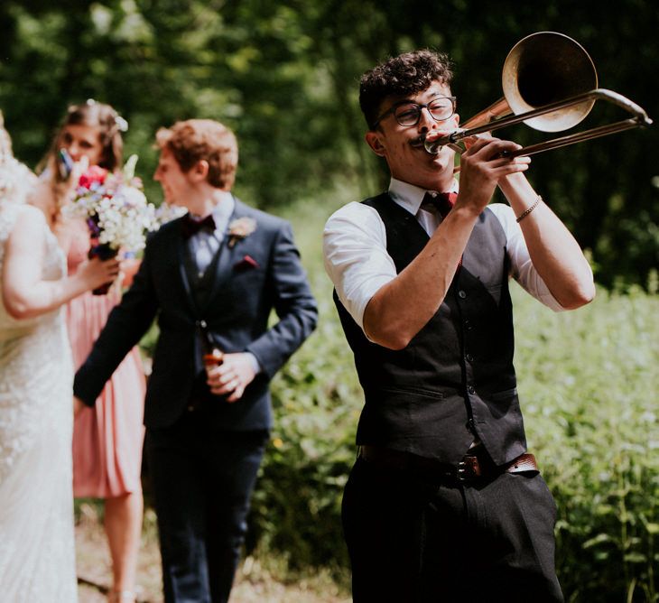 Brass Band Procession | Bride in Catherine Deane Gown | Groom in Ben Sherman Suit, Bow Tie & Gingham Shirt | Colourful Outdoor Wedding at Lineham Farm in Leeds | Shutter Go Click Photography