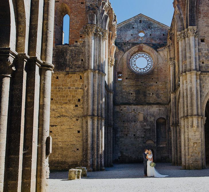 Bride in Justin Alexander Wedding Dress | Groom in Gresham Blake Suit | Outdoor Destination wedding at San Galgano Abbey, near Siena | Lush Imaging | Mrs Mash Up Films