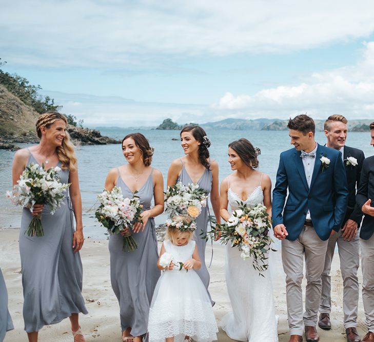 Wedding Party | Bride in Estelle Sally Eagle Gown | Bridesmaids in Powder Blue Evolution Clothing Dresses | Groomsmen in Chinos & Blazers | Outdoor Coastal Wedding at Ohawini Bay in New Zealand with Natural Garden Party Reception | Miss Gen Photography