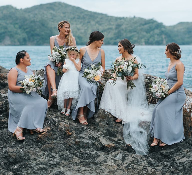 Bridal Party | Bride in Estelle Sally Eagle Gown | Bridesmaids in Powder Blue Evolution Clothing Dresses | Outdoor Coastal Wedding at Ohawini Bay in New Zealand with Natural Garden Party Reception | Miss Gen Photography