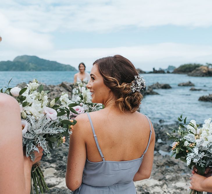 Bridesmaids in Powder Blue Evolution Clothing Dresses | Outdoor Coastal Wedding at Ohawini Bay in New Zealand with Natural Garden Party Reception | Miss Gen Photography