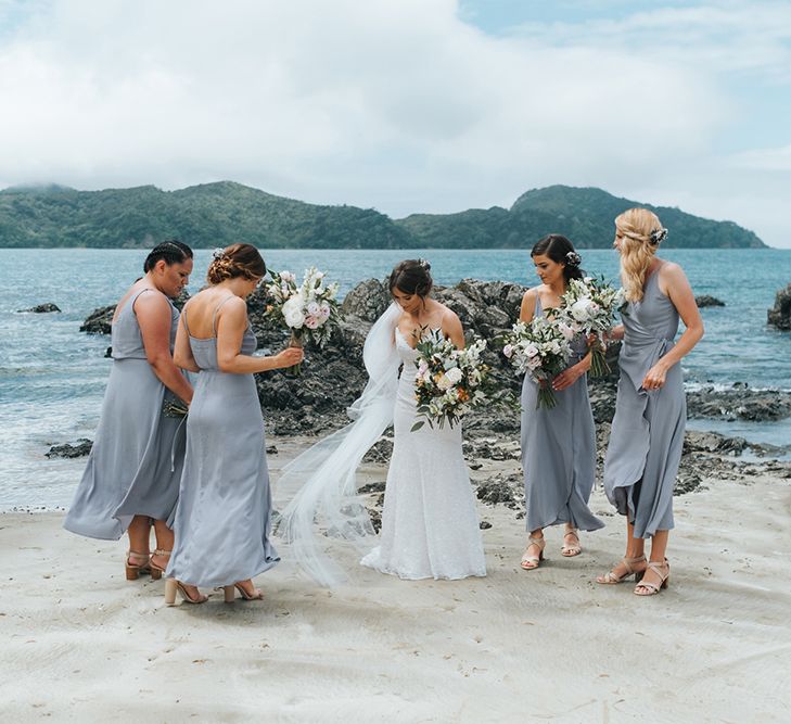 Bridal Party | Bride in Estelle Sally Eagle Gown | Bridesmaids in Powder Blue Evolution Clothing Dresses | Outdoor Coastal Wedding at Ohawini Bay in New Zealand with Natural Garden Party Reception | Miss Gen Photography