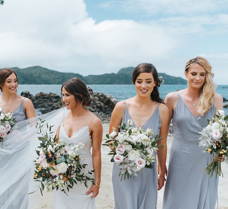 Bridal Party | Bride in Estelle Sally Eagle Gown | Bridesmaids in Powder Blue Evolution Clothing Dresses | Outdoor Coastal Wedding at Ohawini Bay in New Zealand with Natural Garden Party Reception | Miss Gen Photography