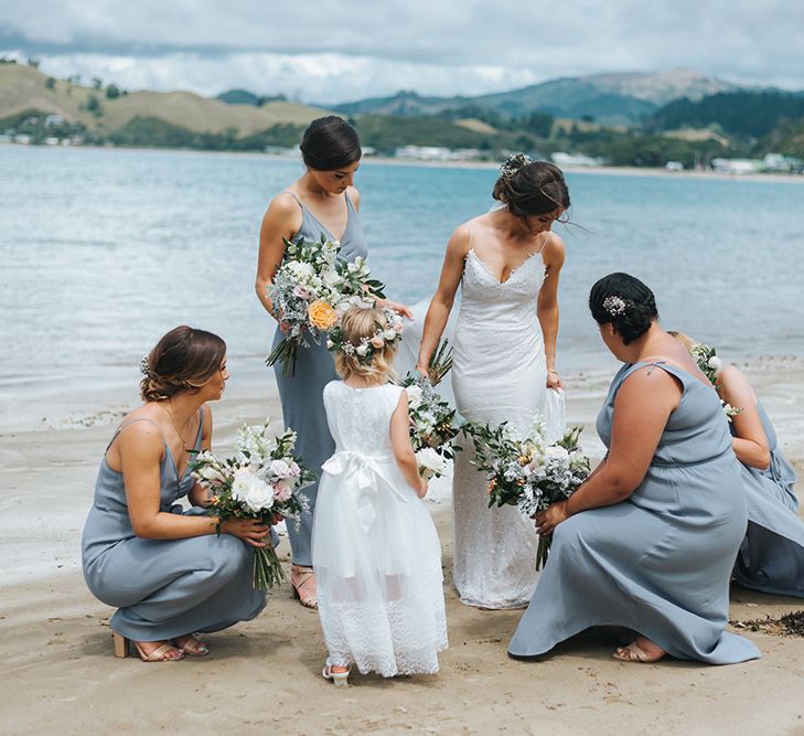 Bridal Party | Bride in Estelle Sally Eagle Gown | Bridesmaids in Powder Blue Evolution Clothing Dresses | Outdoor Coastal Wedding at Ohawini Bay in New Zealand with Natural Garden Party Reception | Miss Gen Photography