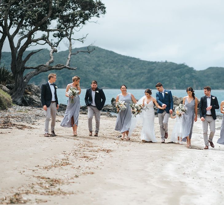 Wedding Party | Bride in Estelle Sally Eagle Gown | Bridesmaids in Powder Blue Evolution Clothing Dresses | Groomsmen in Grey Chinos & Navy Blazers | Outdoor Coastal Wedding at Ohawini Bay in New Zealand with Natural Garden Party Reception | Miss Gen Photography