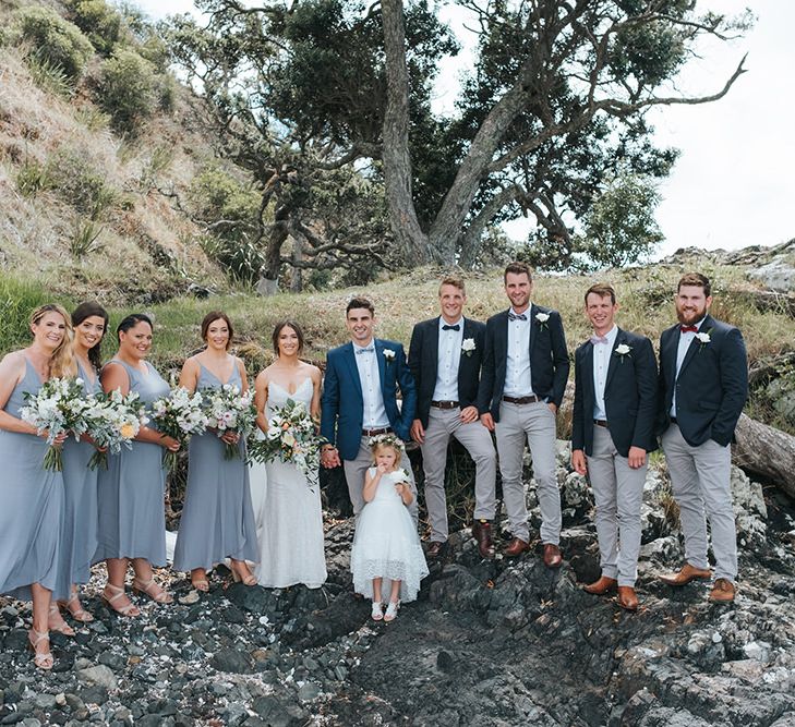 Wedding Party | Bride in Estelle Sally Eagle Gown | Bridesmaids in Powder Blue Evolution Clothing Dresses | Groomsmen in Grey Chinos & Navy Blazers | Outdoor Coastal Wedding at Ohawini Bay in New Zealand with Natural Garden Party Reception | Miss Gen Photography