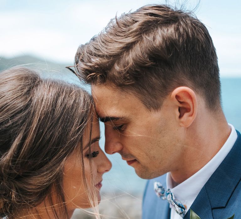 Bride in Estelle Sally Eagle Gown | Groom in Grey Chinos & Navy Blazer | Outdoor Coastal Wedding at Ohawini Bay in New Zealand with Natural Garden Party Reception | Miss Gen Photography