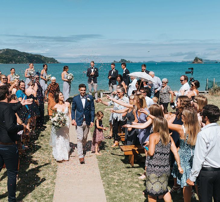 Wedding Ceremony | Bride in Estelle Sally Eagle Gown | Groom in Chinos & Blazer | Outdoor Coastal Wedding at Ohawini Bay in New Zealand with Natural Garden Party Reception | Miss Gen Photography