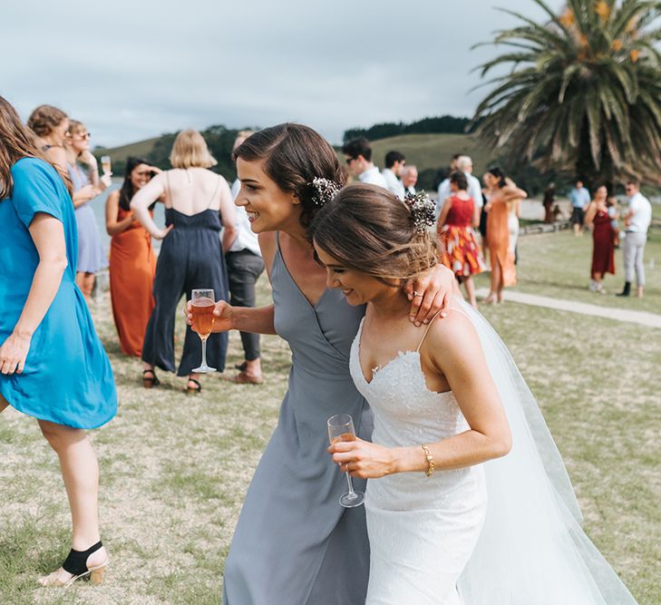 Bride in Estelle Sally Eagle Gown | Bridesmaid in Powder Blue Dress | Outdoor Coastal Wedding at Ohawini Bay in New Zealand with Natural Garden Party Reception | Miss Gen Photography