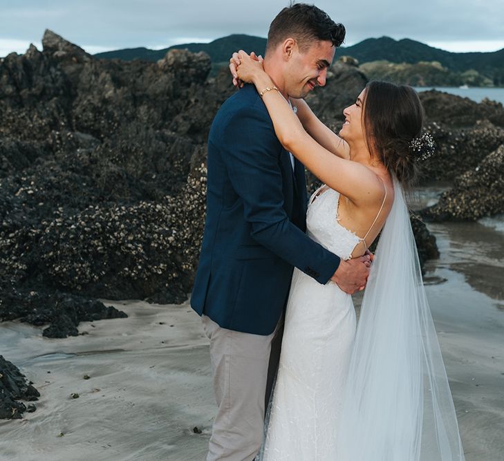 Bride in Estelle Sally Eagle Gown | Groom in Chinos & Blazer | Outdoor Coastal Wedding at Ohawini Bay in New Zealand with Natural Garden Party Reception | Miss Gen Photography