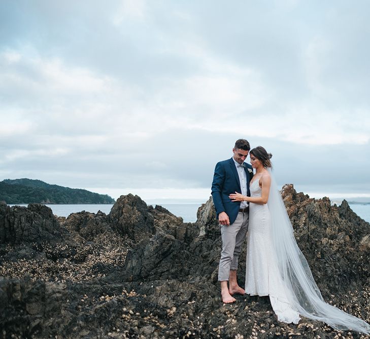 Bride in Estelle Sally Eagle Gown | Groom in Chinos & Blazer | Outdoor Coastal Wedding at Ohawini Bay in New Zealand with Natural Garden Party Reception | Miss Gen Photography