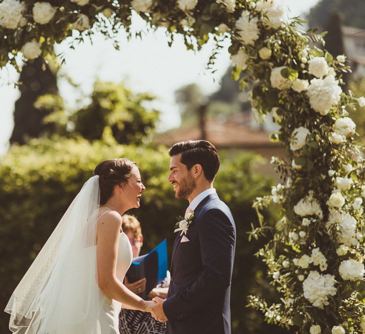 Floral Arch | Wedding Ceremony | Bride in Karen Willis Holmes Gown | Groom in Navy Peter Jackson Suit | Outdoor Destination Wedding at Villa Regina Teodolinda, Lake Como, Italy | Matt Penberthy Photography