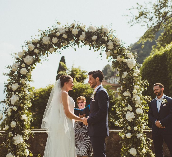 Floral Arch | Wedding Ceremony | Bride in Karen Willis Holmes Gown | Groom in Navy Peter Jackson Suit | Outdoor Destination Wedding at Villa Regina Teodolinda, Lake Como, Italy | Matt Penberthy Photography