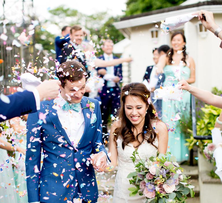 Bride in Pronovias Gown & Groom Navy in Kin by John Lewis Suit Confetti Moment