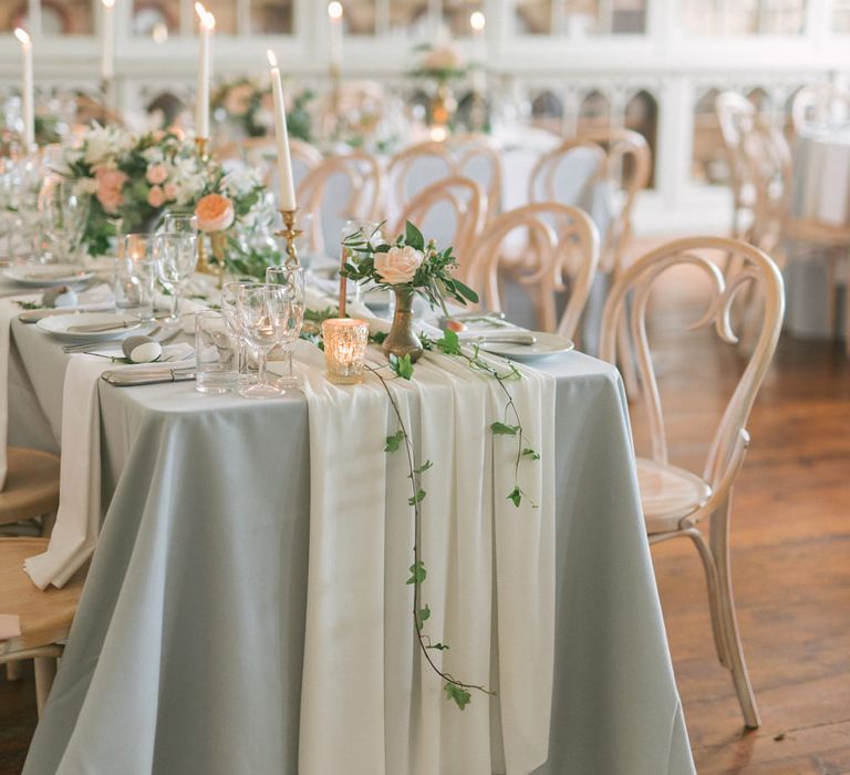 Wedding breakfast tablescape with bent wood chairs, table cloth and tapered candles - Fine Art Wedding Photographer