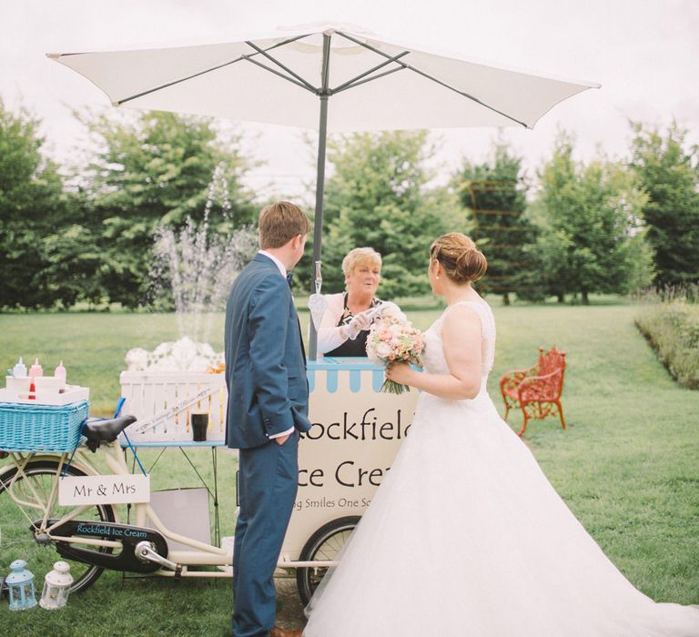 Bride in Modeca Wedding Dress & Groom in Navy Three Piece Suit