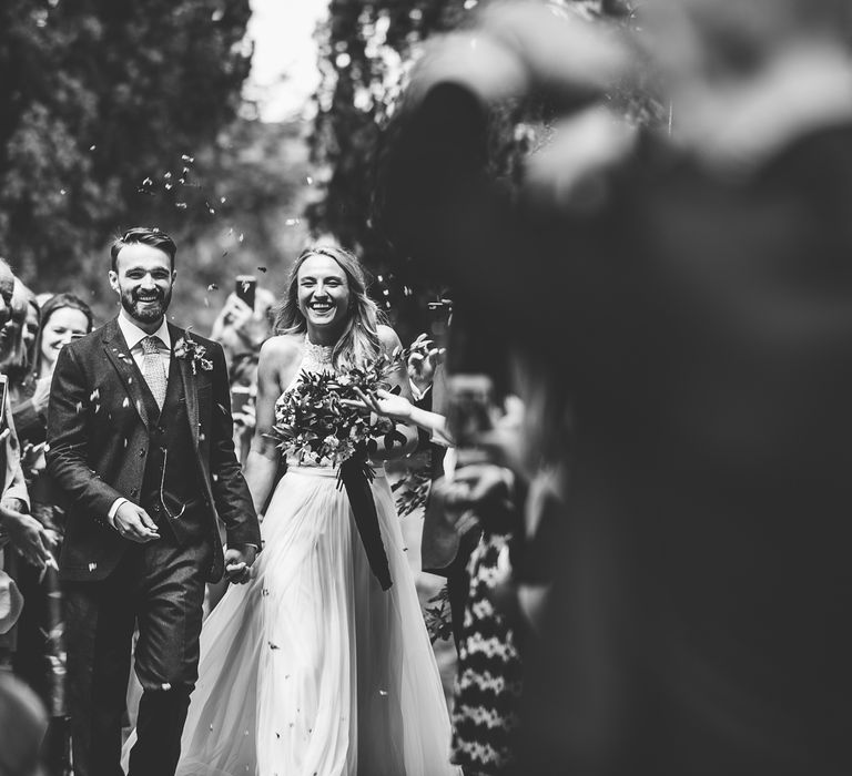 Confetti Exit | Bride in Catherine Deane Carly Bridal Gown | Groom in Navy Suit | Bright At Home Tipi Wedding | Barney Walters Photography