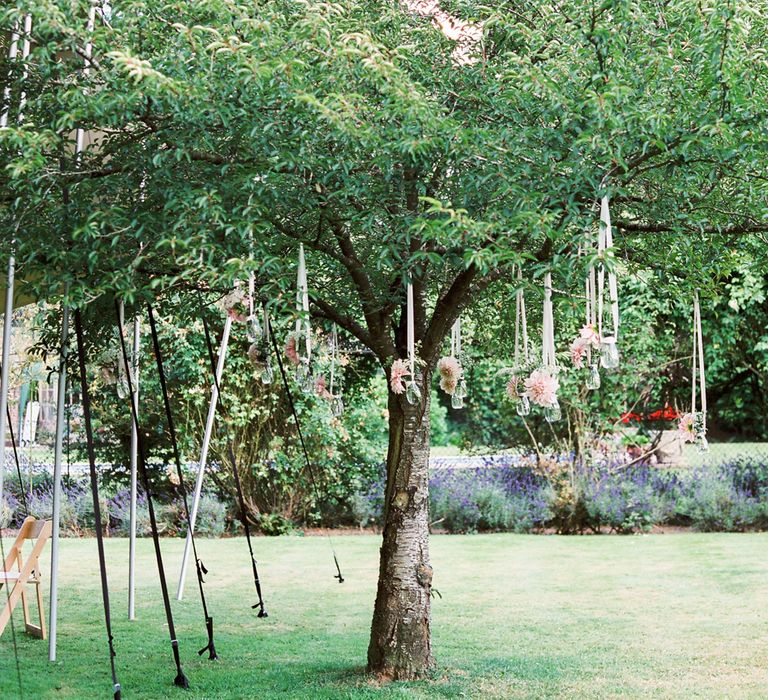 Dahlias in jam jars hanging from trees