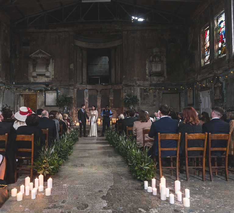 Wedding Ceremony | Candle Light & Greenery Aisle | Bride in Story of My Dress Bridal Gown | Groom in Navy Suit from Tom James Tailors | Vintage Wedding at The Asylum & Town hall Hotel London | Kevin Fern Photography