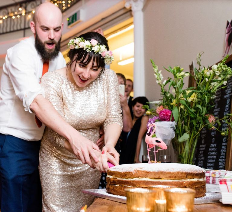 Cutting the Cake with Bride in Pre Owned Gold Sequin Badgley Mischka Wedding Dress & Groom in Suit Supply