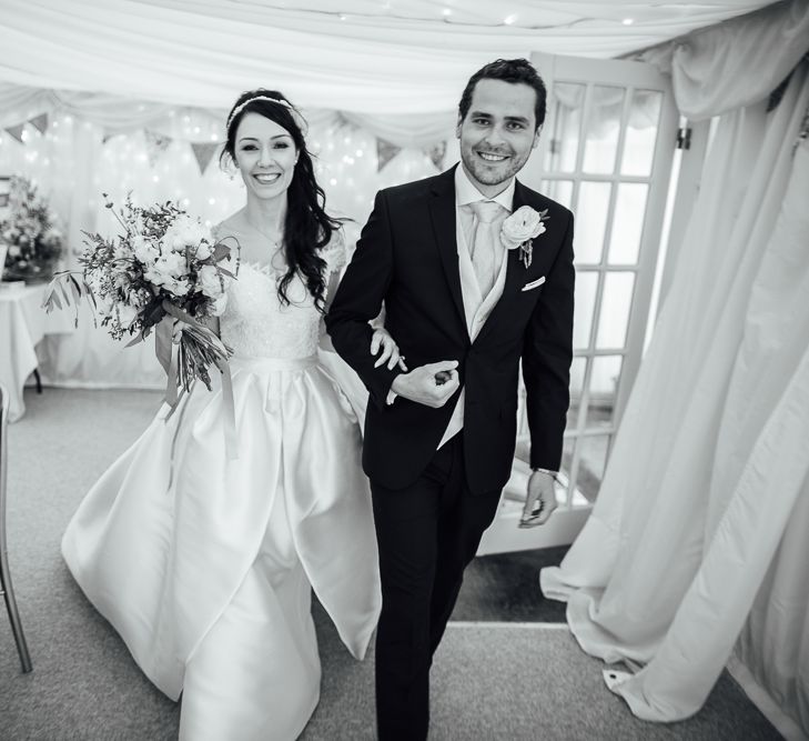 Bride in Aire Barcelona Bridal Gown & Groom in Ted Baker Suit