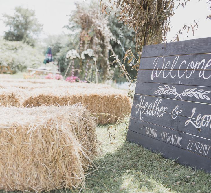 Outdoor Wedding Ceremony With Haybale Seating & Chalkboard Sign