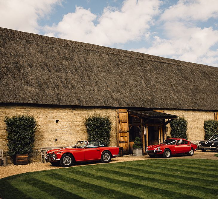 Red Vintage Cars Outside The Tythe Barn in Oxfordshire