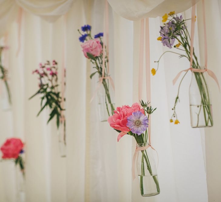 Hanging Bottles with Wild Flower Stems Wedding Decor