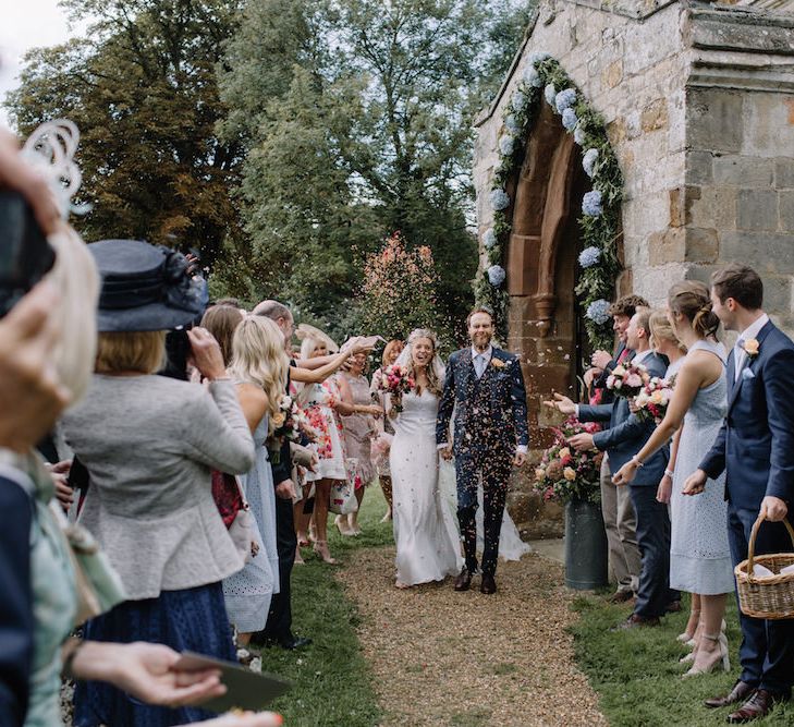 Confetti Exit | Bride in a Temperley Cressida Gown | Groom in Sandro Suit | Rural Wedding in a Sailcloth Tent on Stanford Hall Estate, Northamptonshire | Rebecca Goddard Photography