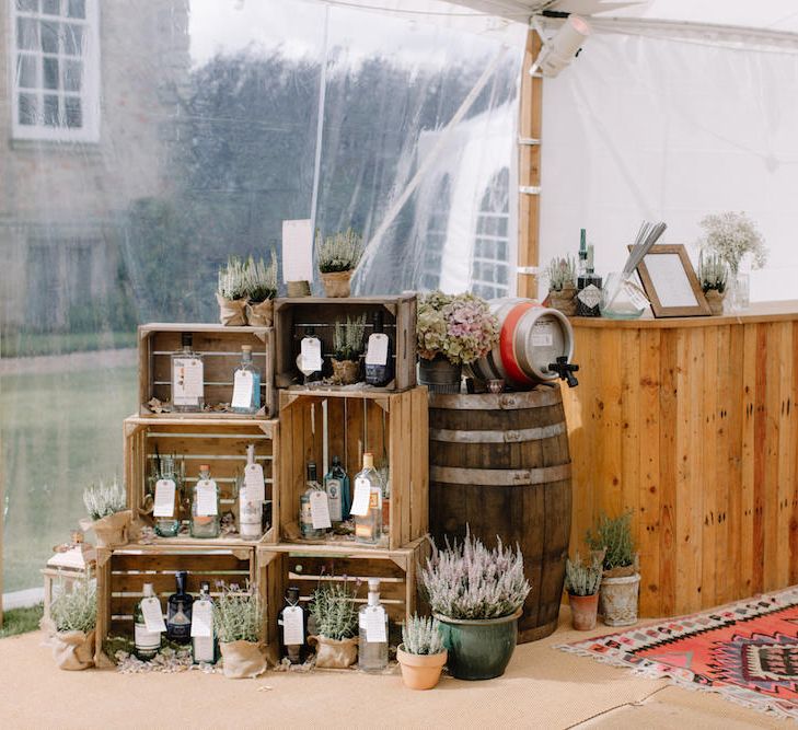 Rustic Wooden Crate & Gin Bottle Table Plan & Bar | Rural Wedding in a Sailcloth Tent on Stanford Hall Estate, Northamptonshire | Rebecca Goddard Photography