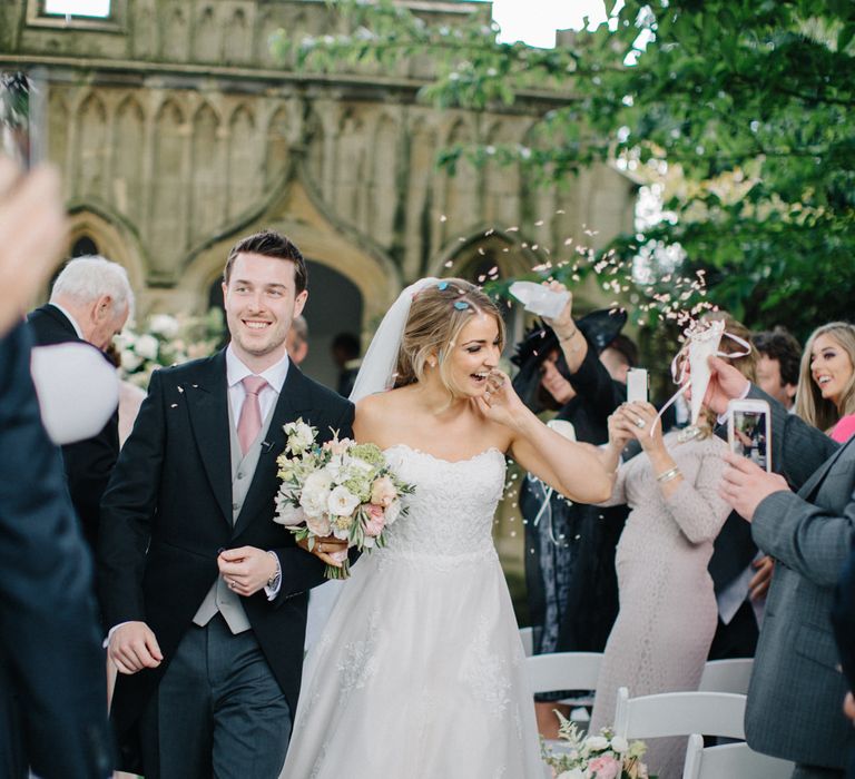 Confetti Exit | Wedding Ceremony | Bridein Princess Gown | Groom in Top Hat & Tails | Outdoor Pastel Country Garden Wedding at Barnsley House in Cirencester | M and J Photography | Motion Farm Wedding Films