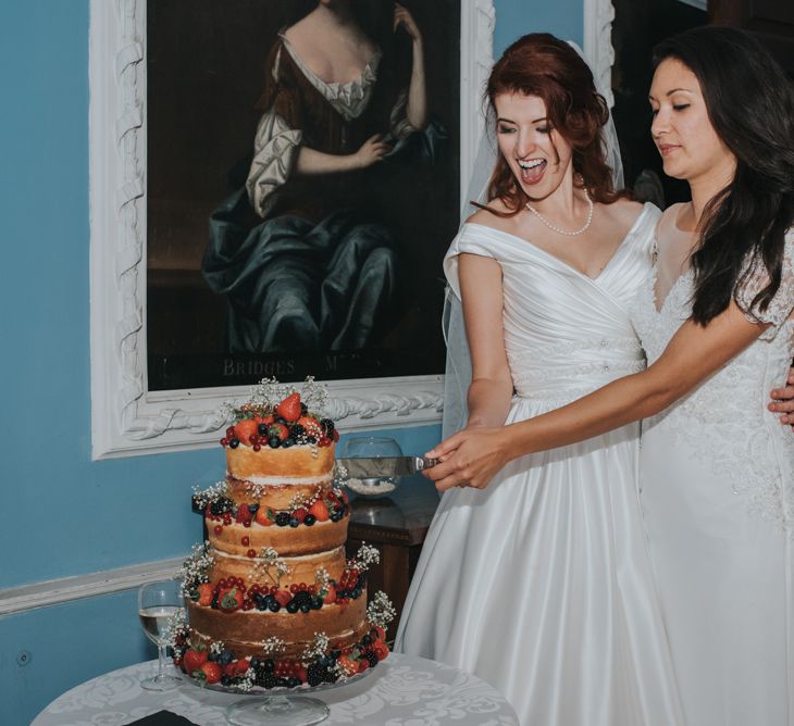 Two Brides inOcean Bridal Studio Wedding Dress & White Leaf Bridal Wedding Dress Cutting The Cake