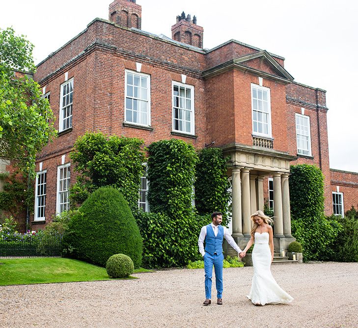 Bride in Pronovias Wedding Dress & Groom in Blue Hugo Boss Suit Outside Iscoyd Park in Shropshire